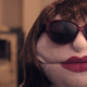 A puppet wearing sunglasses and red lipstick faces the camera in horror-comedy short Snore.